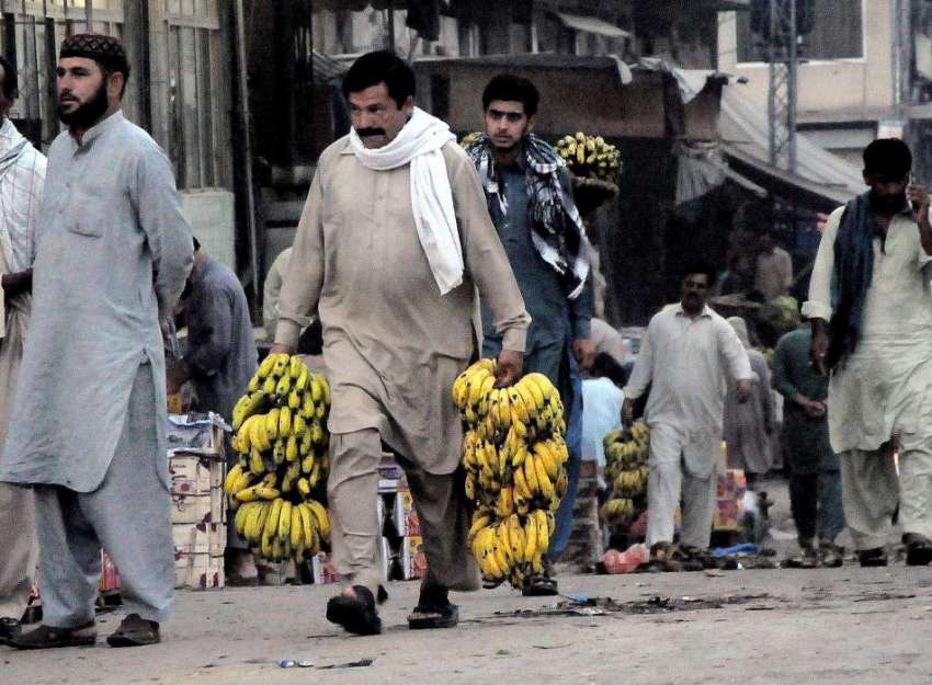 راولپنڈی: فروڈ منڈی میں ایک شہری بیوپاریوں سے کیلے خرید ..