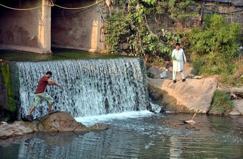 اسلام آباد: بری امام کے قریب پانی عبور کرنے والا شخص۔
