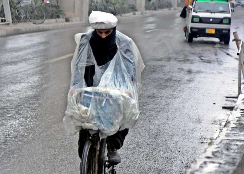 راولپنڈی: بارش سے بچنے کے لیے پلاسٹک شیٹ لپیٹے سائیکل سوار ..