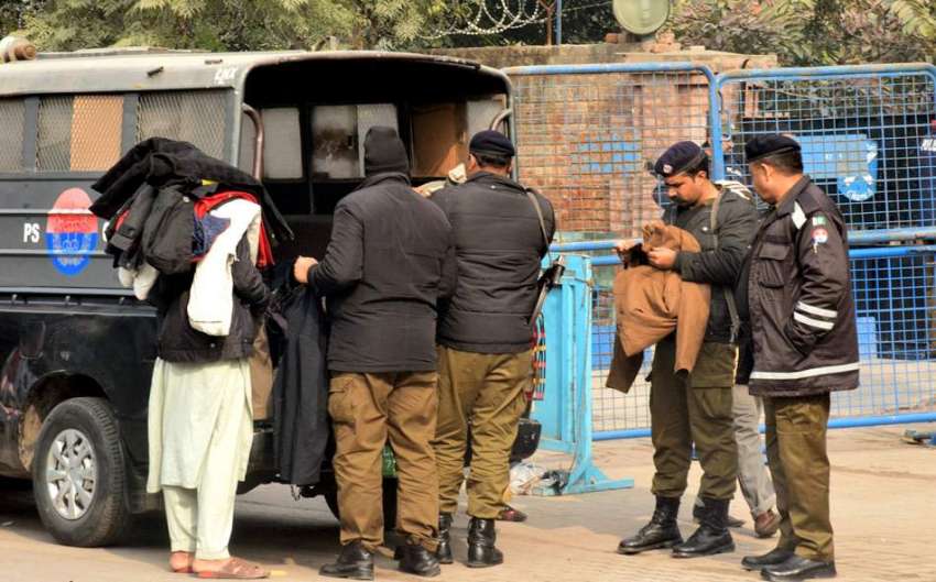 لاہور : پولیس اہلکارایک محنت کش سے گرم جیکیٹس خرید رہے ہیں۔
