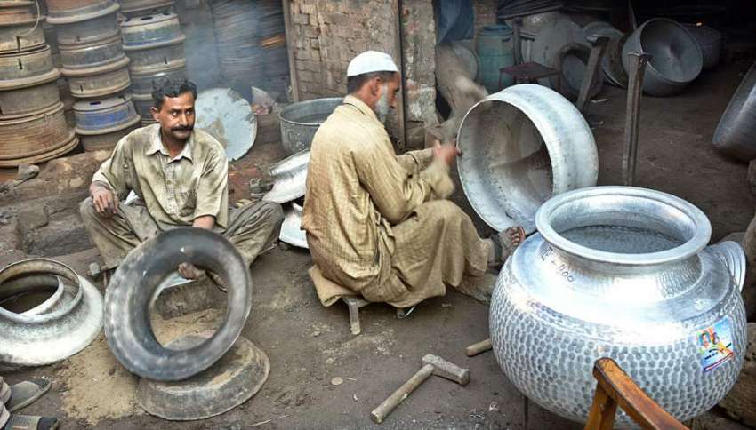 لاہور: مزدور اپنے کام کی جگہ پر لوہے کے مختلف برتنوں کی مرمت ..