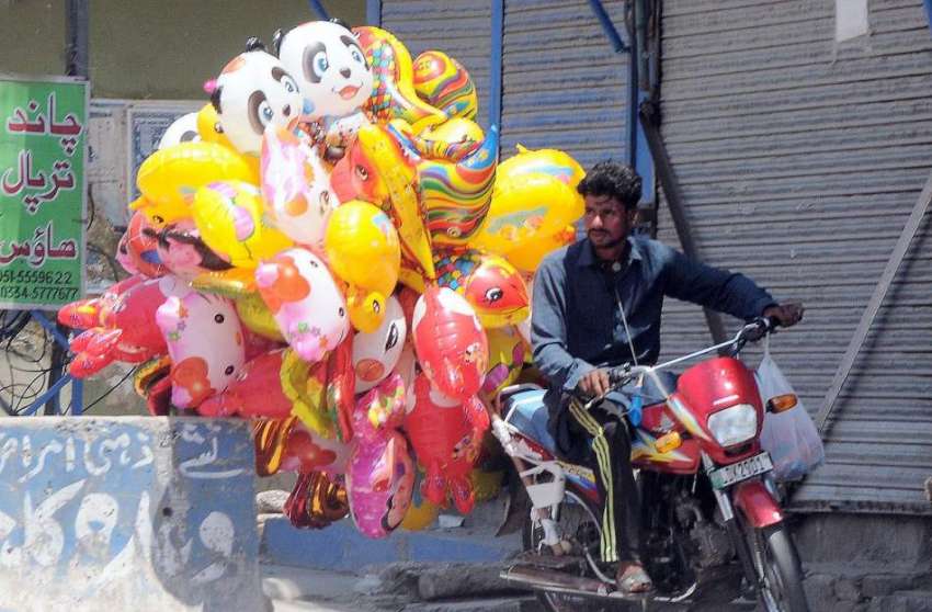 راولپنڈی محنت کش موٹر سائیکل پرکھلونے نما غبارے فروخت کرنے ..
