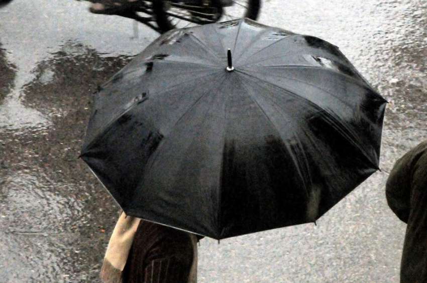 راولپنڈی: دن بھر جاری رہنے والی بارش کے دوران ایک شہری چھتری ..
