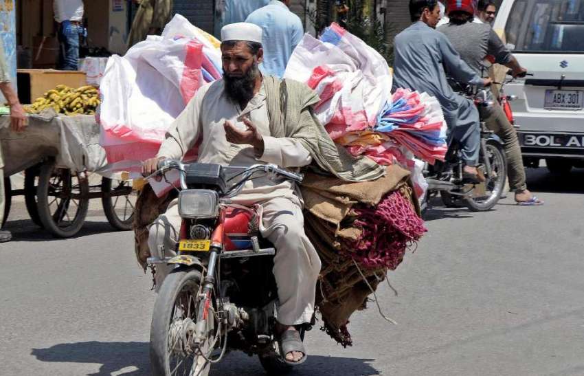 راولپنڈی : محنت کش موٹر سائیکل پر خالی بوریاں اور تھیلے لادے ..