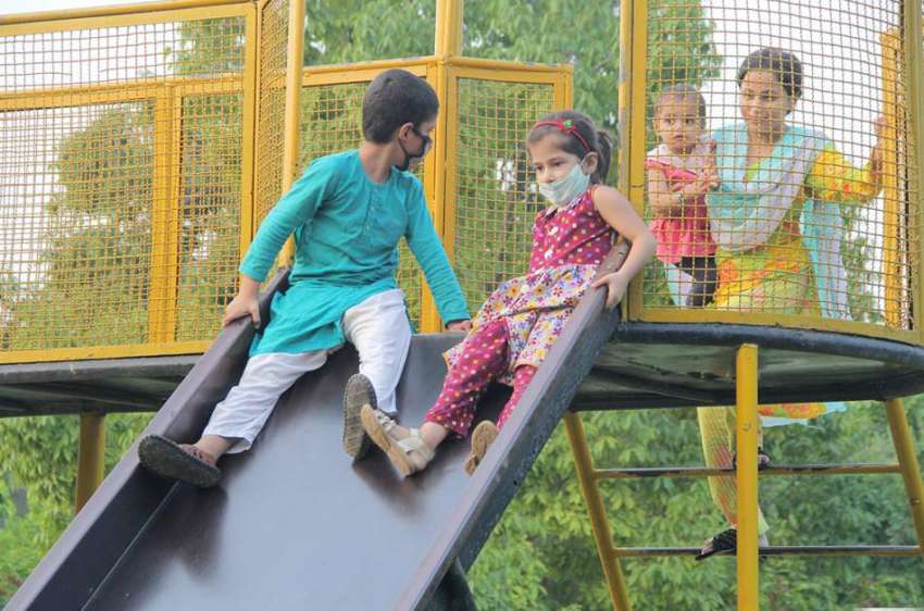 لاہور : باغ جناح میں آنے والے بچے سلائیڈ لے رہے ہیں۔