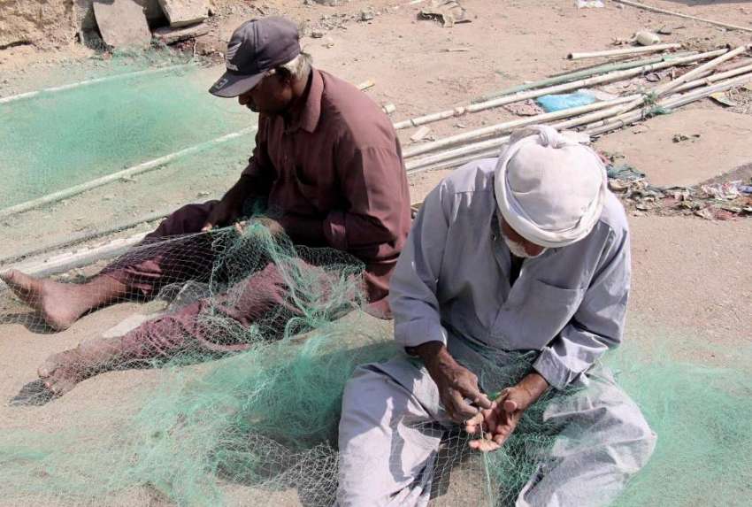 کراچی، مچھرے مچھلی کا جال بنا رہے ہیں۔