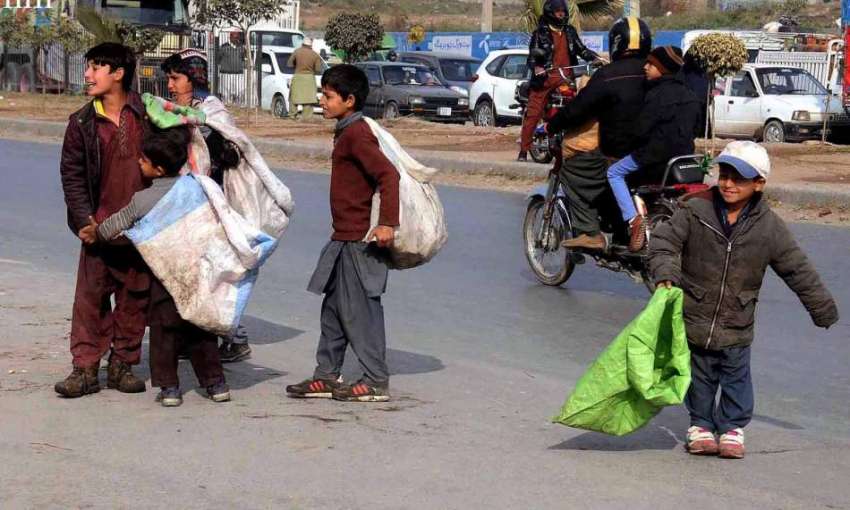 راولپنڈی: کار آمد اشیاء جمع کر نیوالے بچے سڑک کنارے کھڑے ..