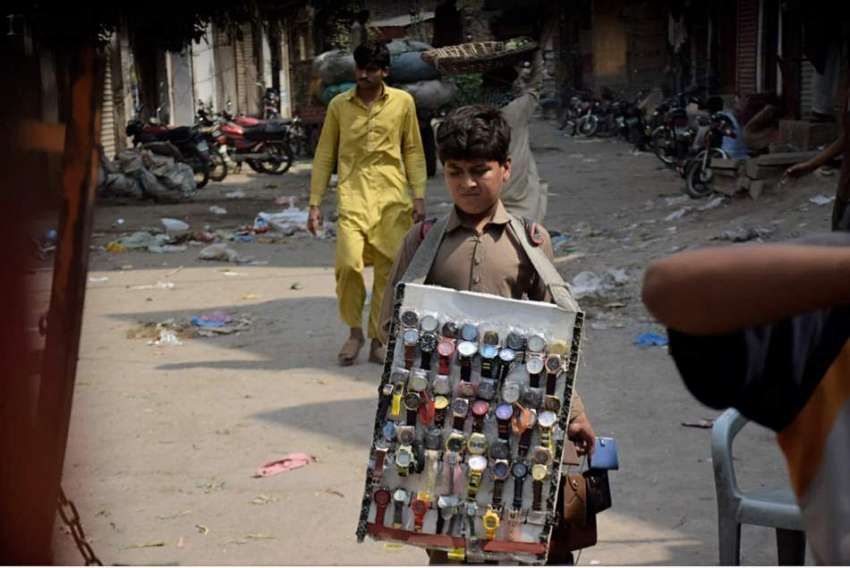 لاہور: ایک محنت کش بچہ گھڑیاں فروخت کررہا ہے۔ 