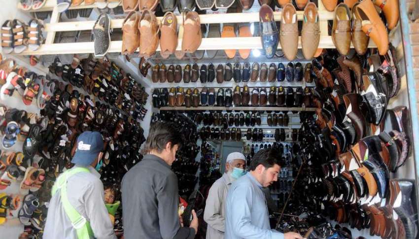 راولپنڈی: لاک ڈاون میں نرمی کے بعد شہری ایک دکان سے جوتے ..