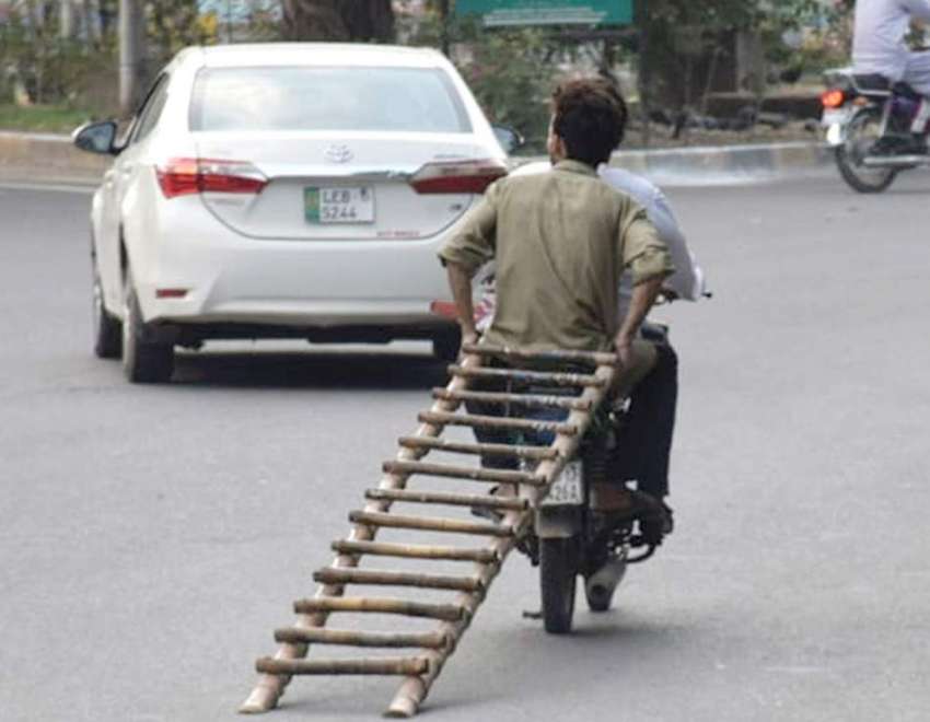لاہور : موٹر سائیکل سوار لکڑی کی سیڑھی لئے جارہے ہیں۔