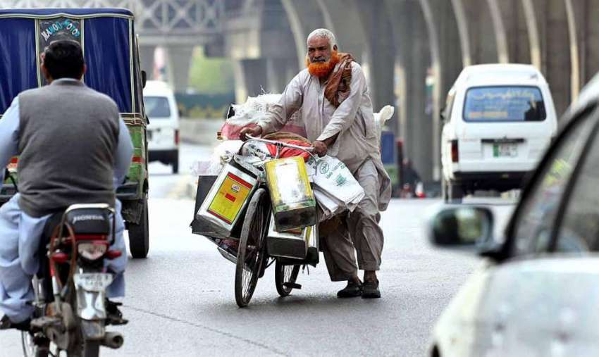 راولپنڈی: مری روڈ پر ایک بزرگ اپنی سائیکل کے ساتھ بھاری بھرکم ..