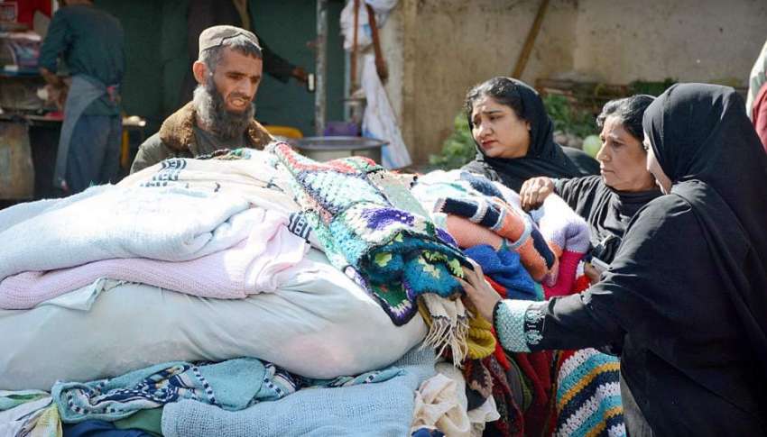 کراچی:سڑک کنارے ایک شخص گرم کپڑے فروخت کر رہا ہے