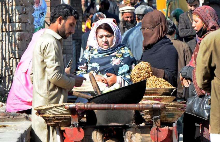 راولپنڈی: خواتین ریڑھی بان سے مکئی کے دانے خرید رہی ہیں۔ ..