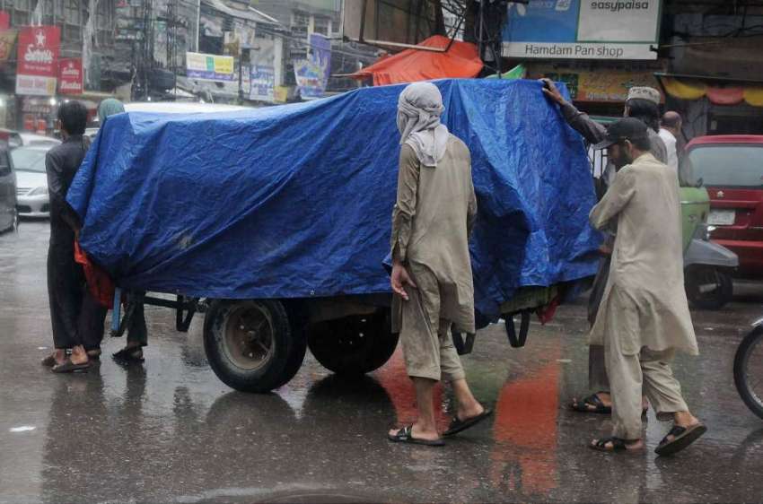 راولپنڈی: بارش سے بچنے کیلے مزدوروں نے سامان پرشیٹ چڑھ رکھی ..
