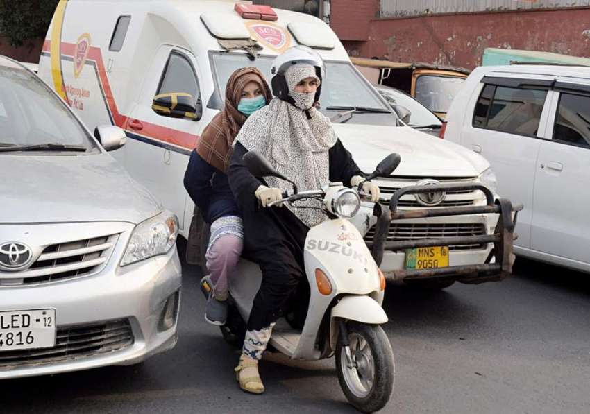 لاہور، دو خواتین سکوٹی پر اپنی منزل کی جانب گامزن ہیں۔