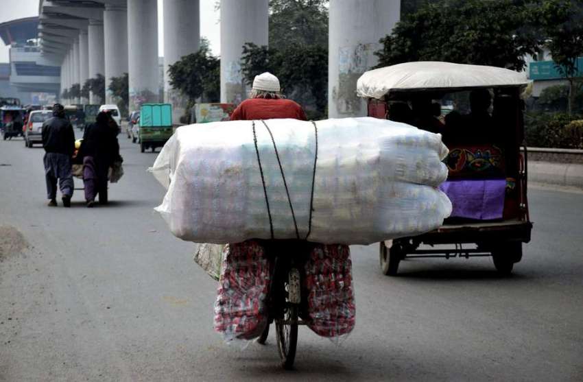 لاہور: ایک بزرگ محنت کش سائیکل پراوورلوڈنگ کئے جارہا ہے۔ ..