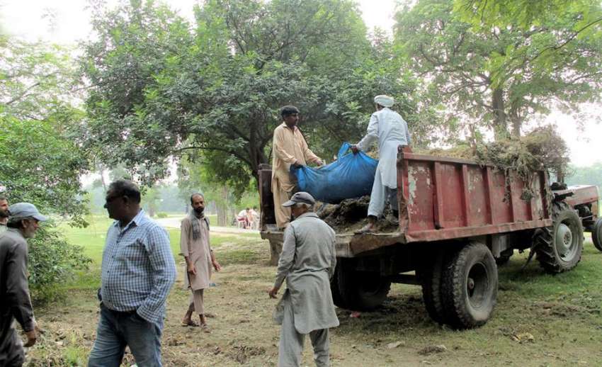 لاہور: پی ایچ اے کے ملازم جیلانی پارک سے کچرا اٹھارہے ہیں۔ ..