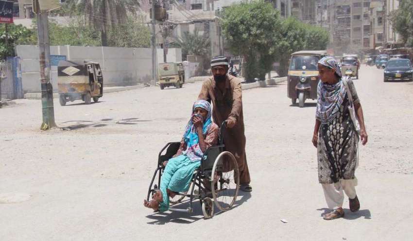 کراچی : لاک ڈوان کے دوران ایک شخص اپنی والدہ کو وہیل چیز پر ..