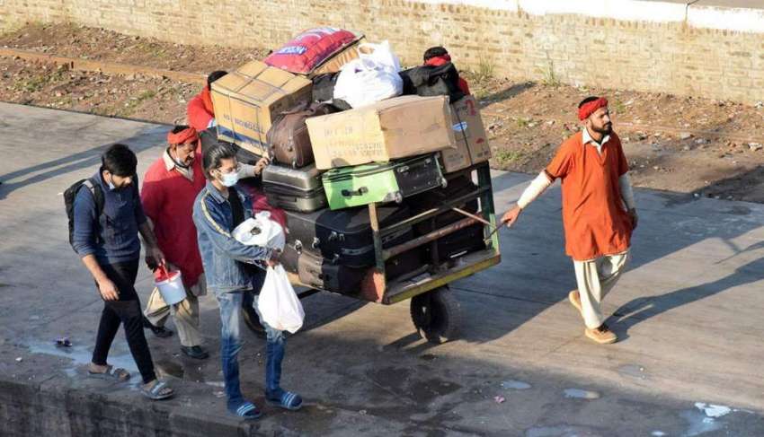 لاہور، قلی ہتھ ریڑھی پر سامان رکھ کر لے جا رہے ہیں۔