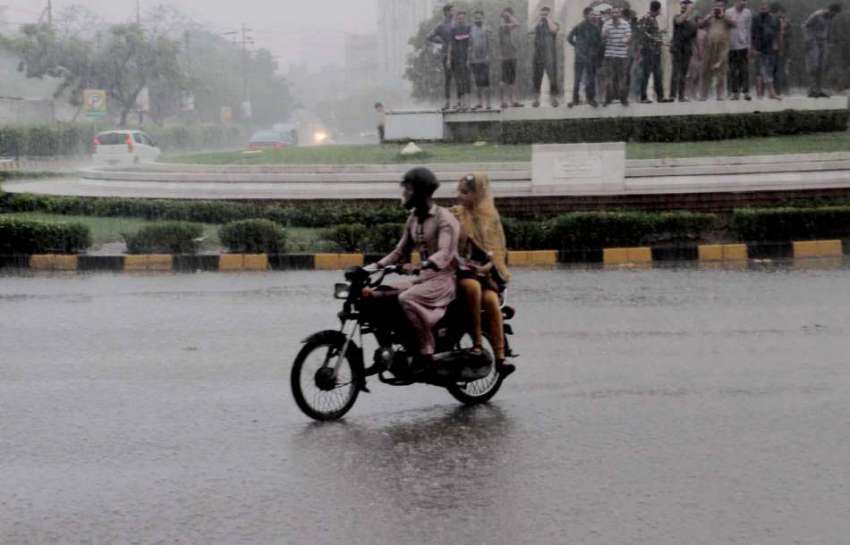 کراچی: بارش کے دوران موٹرسائیکل سوار فیملی گورنر ہاؤس چورنگی ..
