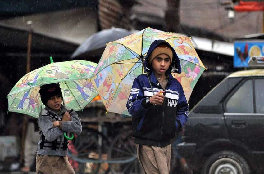 راولپنڈی:بارش سے بچنے کے لئے بچے چھتری تلے اپنی منزل کی طرف ..