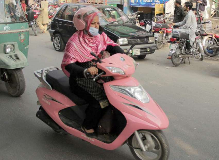 لاہور، ایک خاتون سکوٹی پر اپنی منزل کی جانب رواں دواں ہے۔