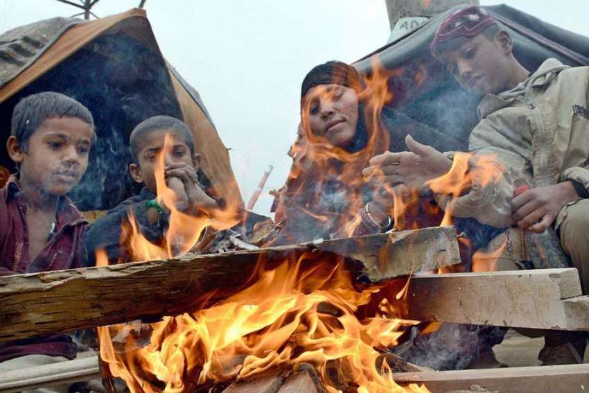 کراچی: کورنگی میں گھر کے باہر خود کو گرم رکھنے کے لئے ایک ..