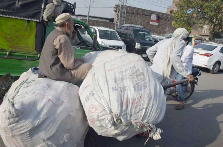 لاہور:ایک محنت کش ہتھ ریڑھی پر بھاری بورے رکھ کر لے جارہا ..