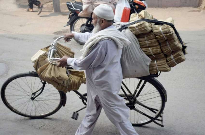 لاہور: ایک بزرگ محنت کش سائیکل پرخاکی لفافے فروخت کرنے کیلئے ..