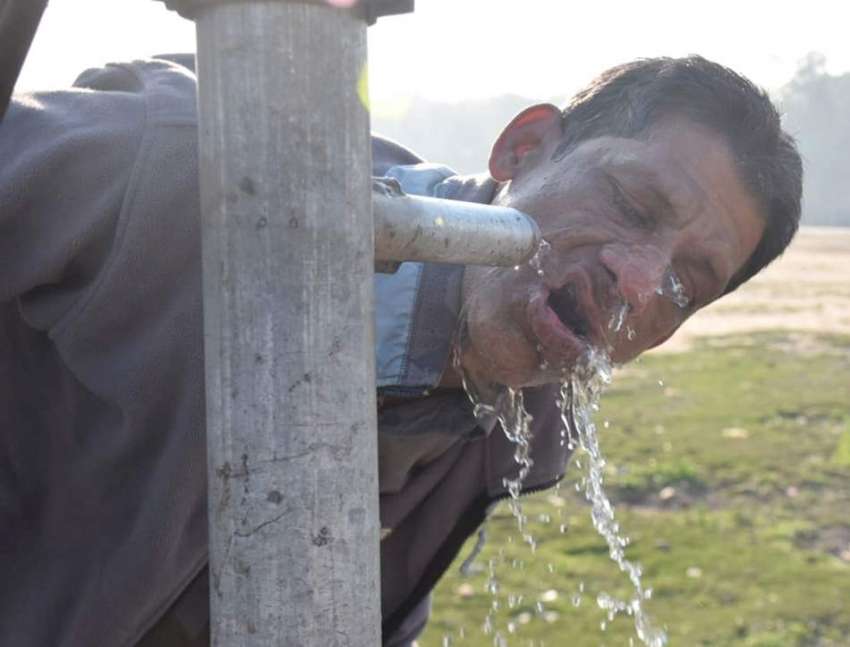 لاہور:ایک شخص راستےمیں لگے ہینڈ پمپ سے پانی پی رہا ہے