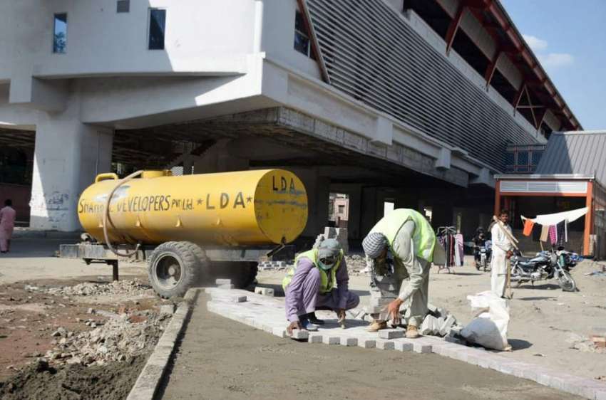 لاہور : مزدور اورنج لائن ٹرین اسٹیشن کے تعمیراتی کام میں ..
