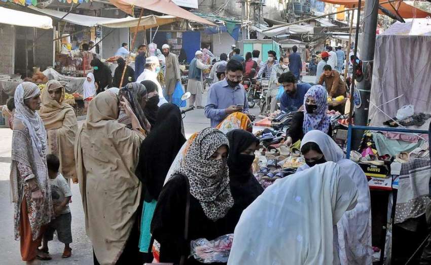 راولپنڈی: موتی بازار کے باہر خواتین جوتوں کی خریداری میں ..