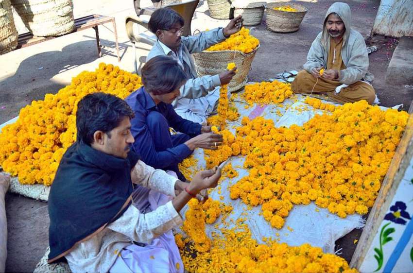 حیدرآباد: کارکن اپنی دکان کے باہر پھولوں کے ہار تیار کررہے ..