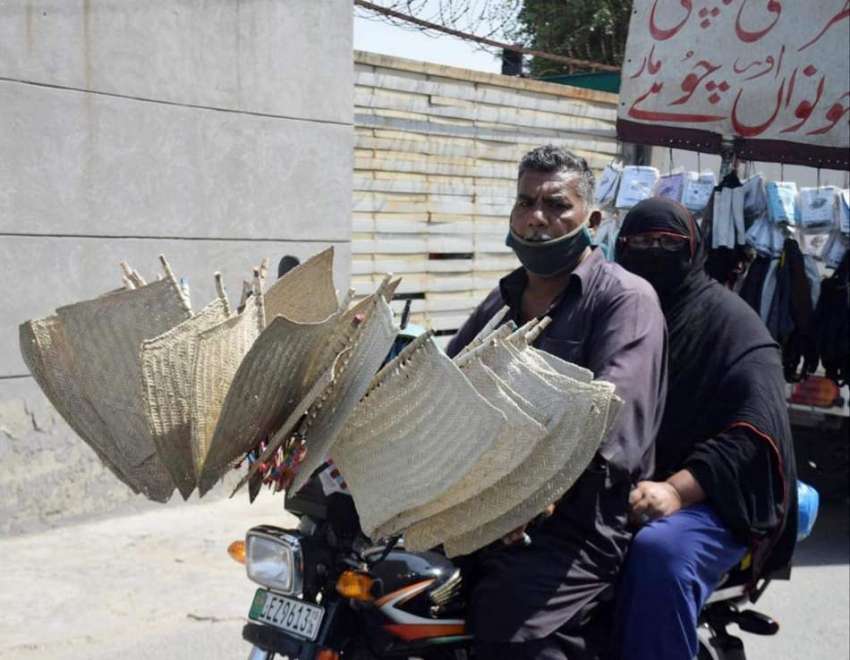 لاہور:گرمی کی شدت میں اضافے کے باعث میاں بیوی موٹرسائیکل ..