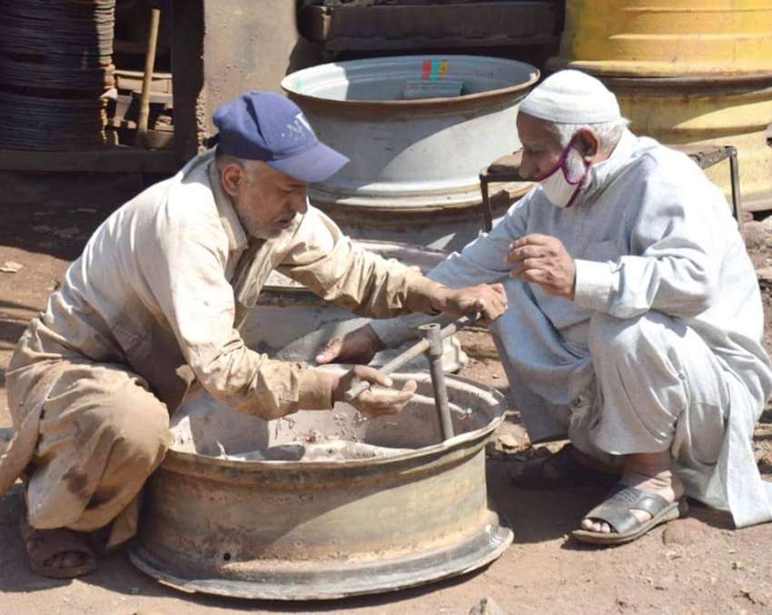لاہور: کاریگر گاڑی کارم مرمت کررہے ہیں