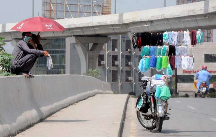 راولپنڈی: محنت کش موٹر سائیکل پر ماسک فروخت کیلئے سجائے ..