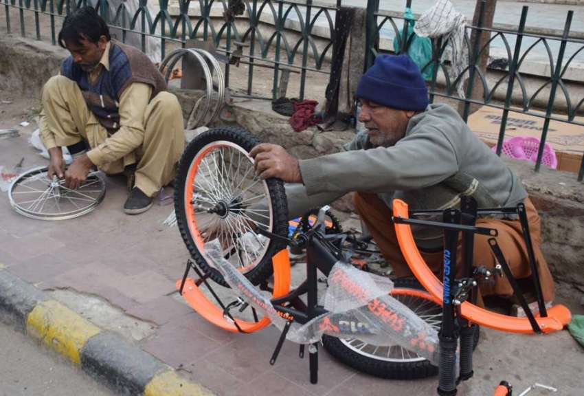 لاہور، ایک کاریگر بچوں کیلئے سائیکل تیار کر رہا ہے۔