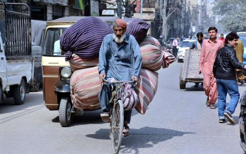 کراچی: ایک محنت کش سائیکل سوار بوریاں لادے جا رہا ہے
