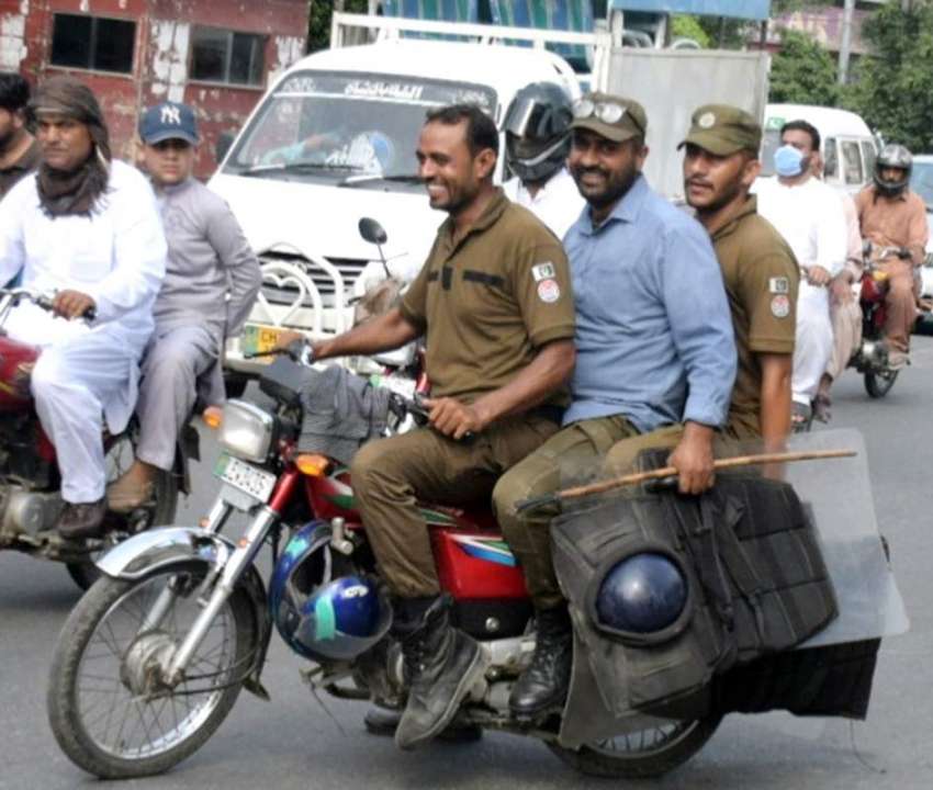 لاہور : موٹرسائیکل پر سوار تین پولیس اہلکار ہیلمٹ اور کورونا ..