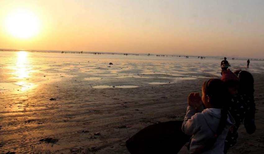 کراچی، ساحل سمندر پر بچیاں 2020 کے آخری سورج کے سامنے 2021 میں ..