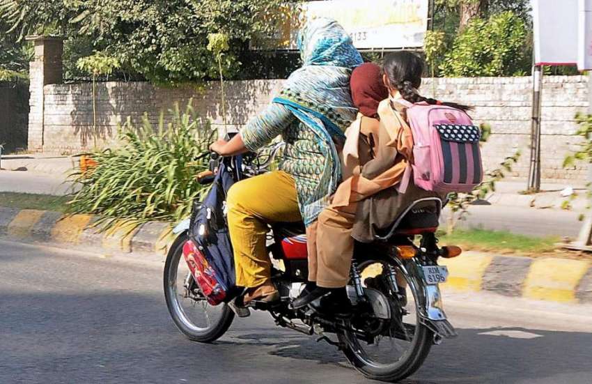 راولپنڈی، سکول سے چھٹی کے بعد ایک خاتون موٹر سائیکل پر اپنے ..