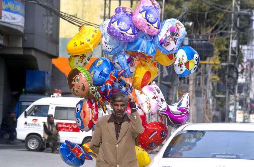 راولپنڈی: ایک محنت کش سڑک کنارے بچوں کے غبارے فروکت کر رہا ..