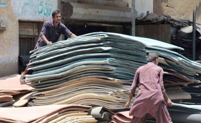 کراچی : مزدورسخت گرمی میں چمڑے کی شیٹیں گودم  منتقل کر رہے ..