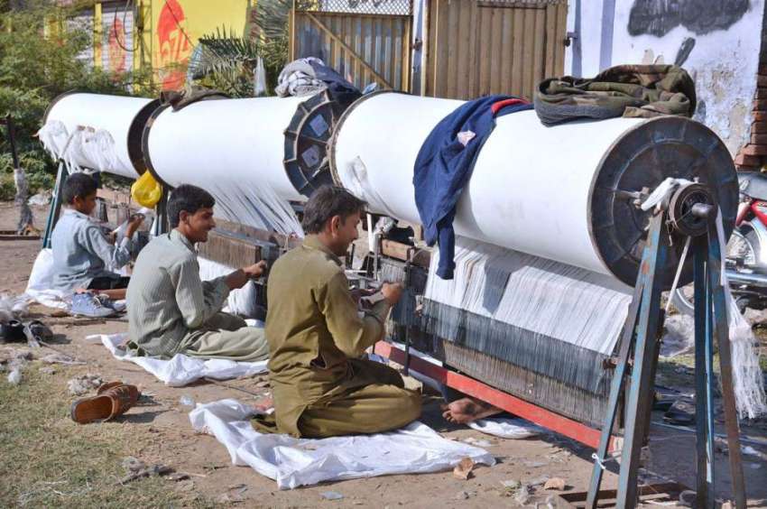 فیصل آباد: مزدور پاور لوم فیکٹری میں روزی کمانے میں مصروف ..