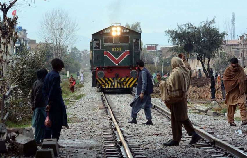 پشاور: ریل کی پٹریوں کو عبور کرنے والے لوگ اسی ٹریک پر ٹرین ..