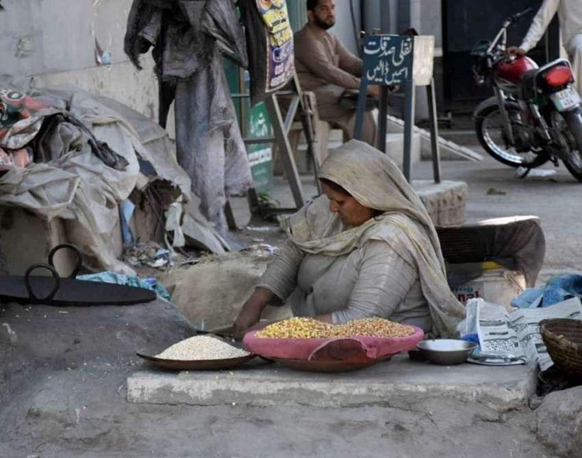 لاہور : ایک محنت کش خاتون بھٹی پر دانے بھون رہی ہے۔