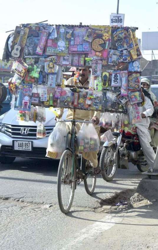 فیصل آباد: ایک دکاندار اپنے سائیکل پر گاہکوں کی تلاش میں ..