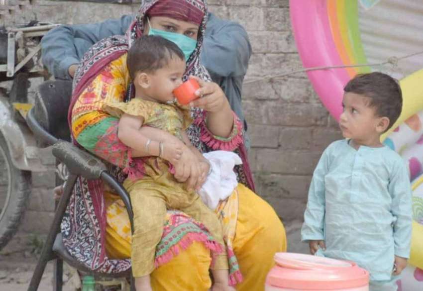 لاہور: گرمی کی شدت کم کرنے کیلئے خاتون اپنی بچی کو پانی پلا ..