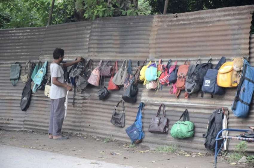 لاہور : ایک شخص مغلپورہ میں سڑک کنارے بیگ فروخت کرنے کیلئے ..