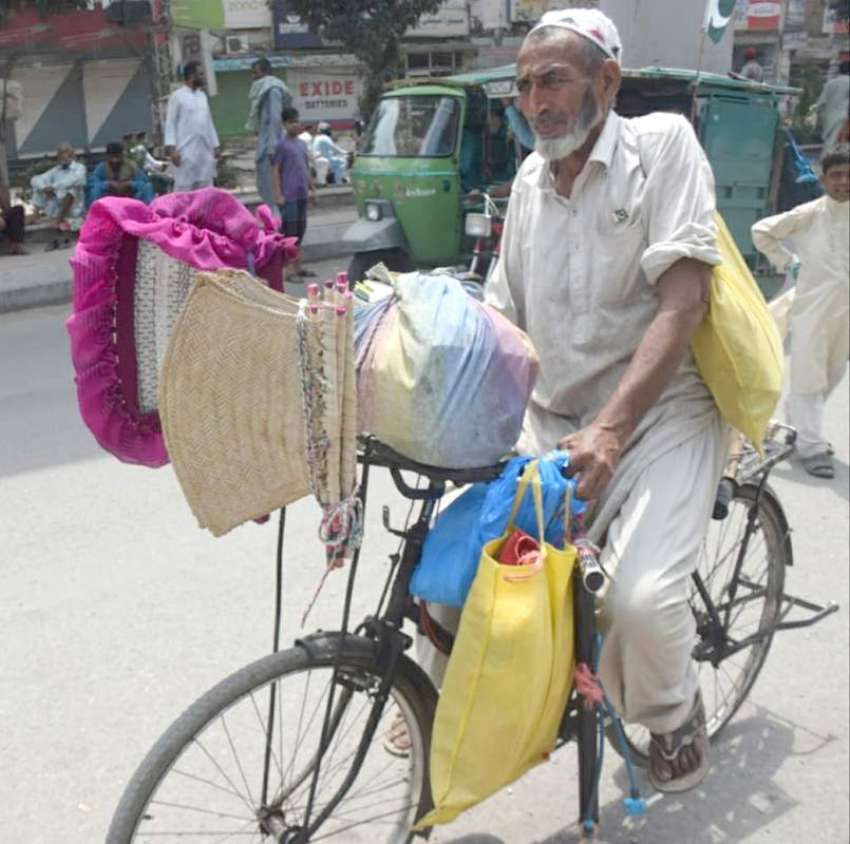 لاہور : ایک بزرگ سائیکل پر ہاتھ سے جھلنے والے پنکھے فروخت ..